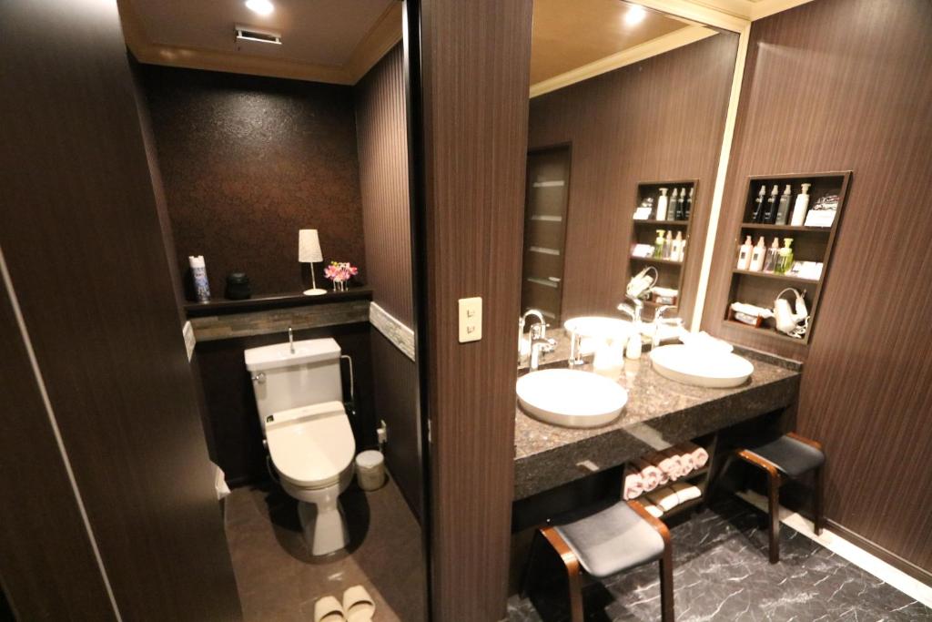 une salle de bain avec deux lavabos et un WC et deux miroirs dans l'établissement Hotel Sari Resort Takinoyashiro (Adults Only), à Kato