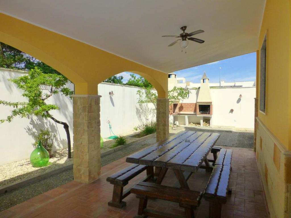 - une table de pique-nique sur la terrasse couverte arrière d'une maison dans l'établissement Villa Suzannah, à Lendinuso