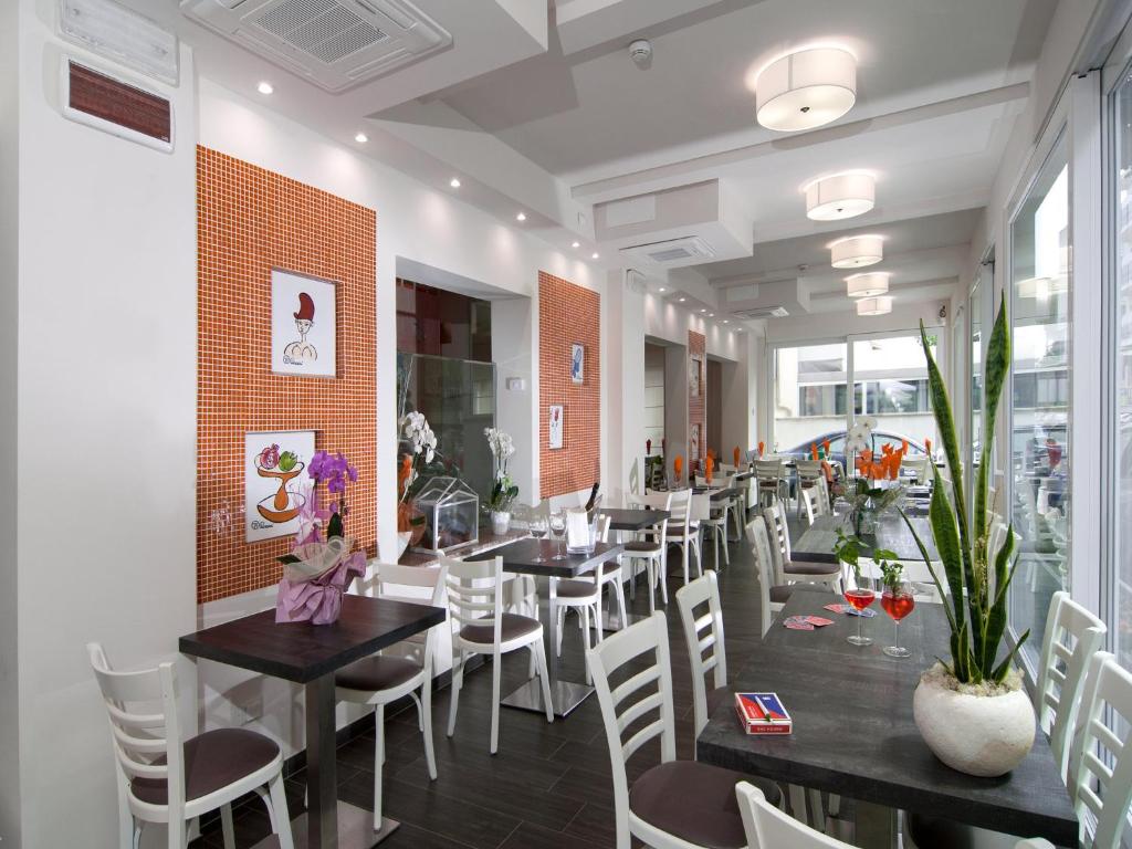 un restaurant avec des tables noires et des chaises blanches dans l'établissement Hotel Casablanca, à Rimini