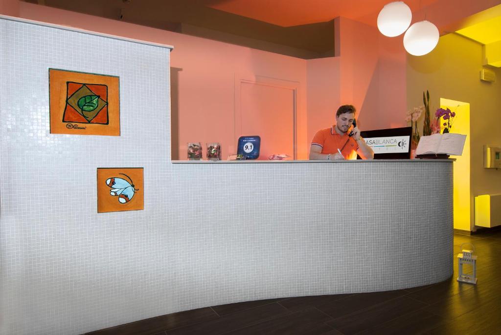 un homme assis à un comptoir dans un restaurant dans l'établissement Hotel Casablanca, à Rimini