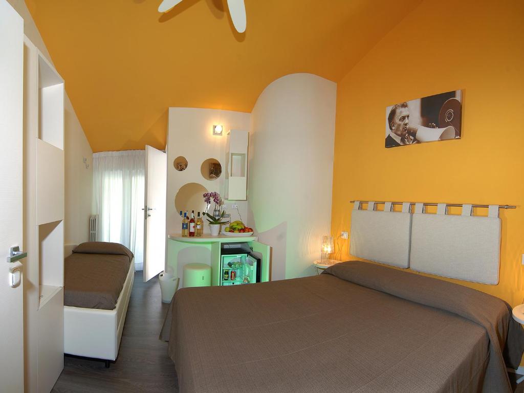 une chambre avec un lit et une chaise dans une pièce dans l'établissement Hotel Casablanca, à Rimini