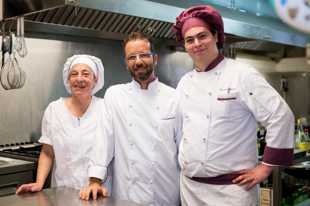 un groupe de trois chefs debout dans une cuisine dans l'établissement Villa Imperiale Hotel, à Spotorno