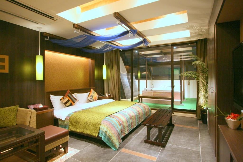 une chambre d'hôtel avec un lit et un canapé dans l'établissement Hotel Aura Daito (Adult Only), à Daitō