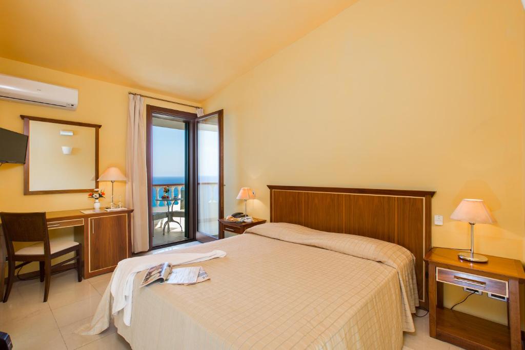 une chambre avec un lit, un bureau et un miroir dans l'établissement Hotel Santa Lucia, à Parghelia