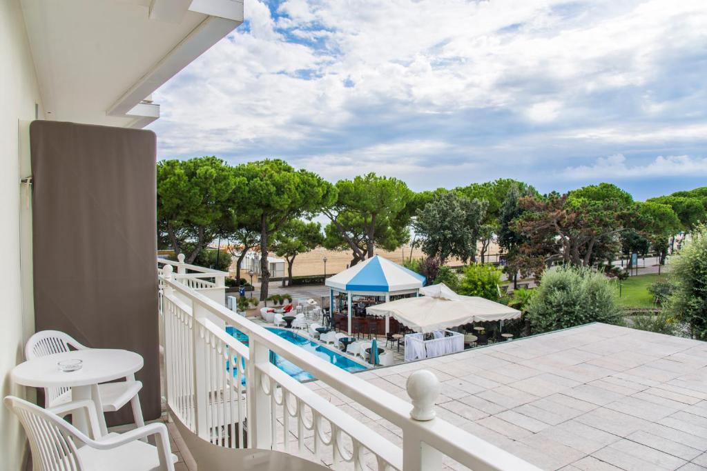 - un balcon avec vue sur la piscine et le complexe dans l'établissement Hotel Miramare, à Lignano Sabbiadoro