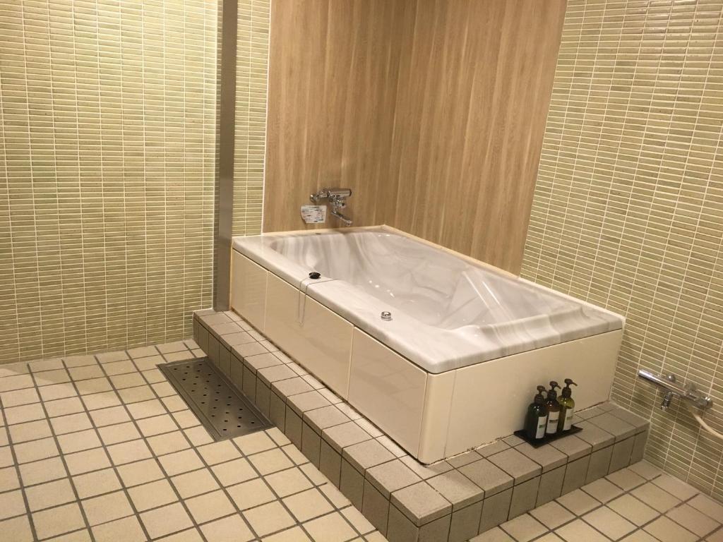 une grande baignoire dans une salle de bain avec un sol carrelé dans l'établissement Hotel Jardin de Fleurs (Adult Only), à Kyoto 31 autres photos