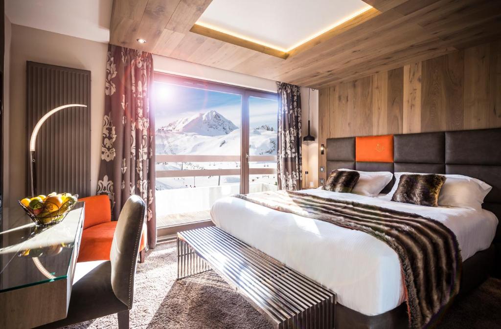 - une chambre avec un grand lit et une vue sur la montagne dans l'établissement Hôtel Taj-I Mah by Les Etincelles, à Arc 2000