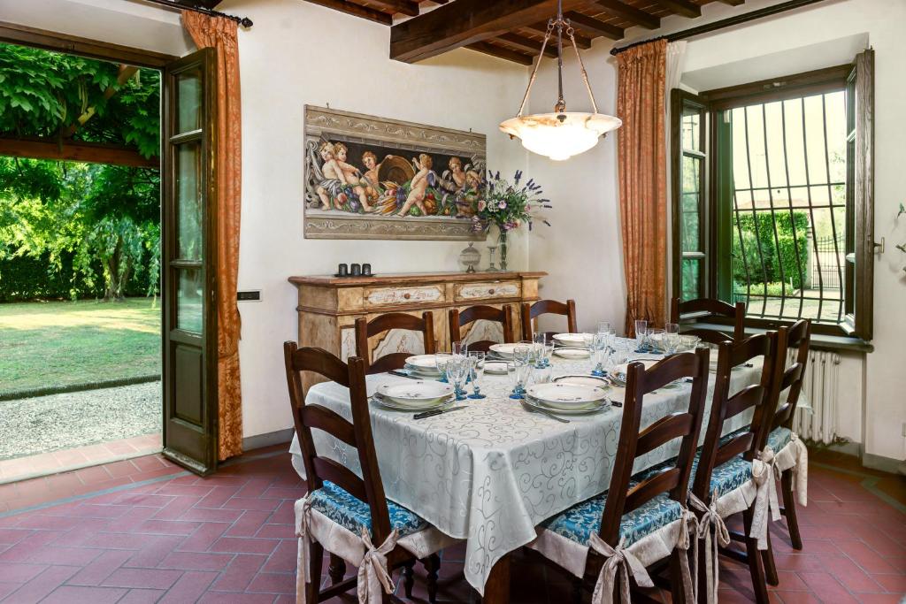 une salle à manger avec une table et des chaises ainsi qu'une peinture murale. dans l'établissement Villa Colombai, à Orentano