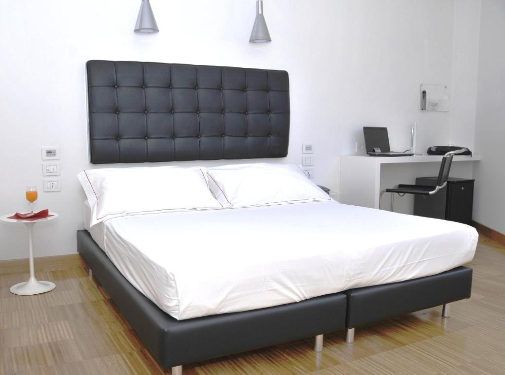 un grand lit avec une tête de lit noire dans une chambre dans l'établissement Hotel Del Conte, à Fondi 36 autres photos