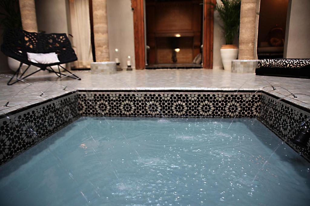 - une piscine d'eau avec une chaise dans la chambre dans l'établissement L'Alcazar, à Rabat