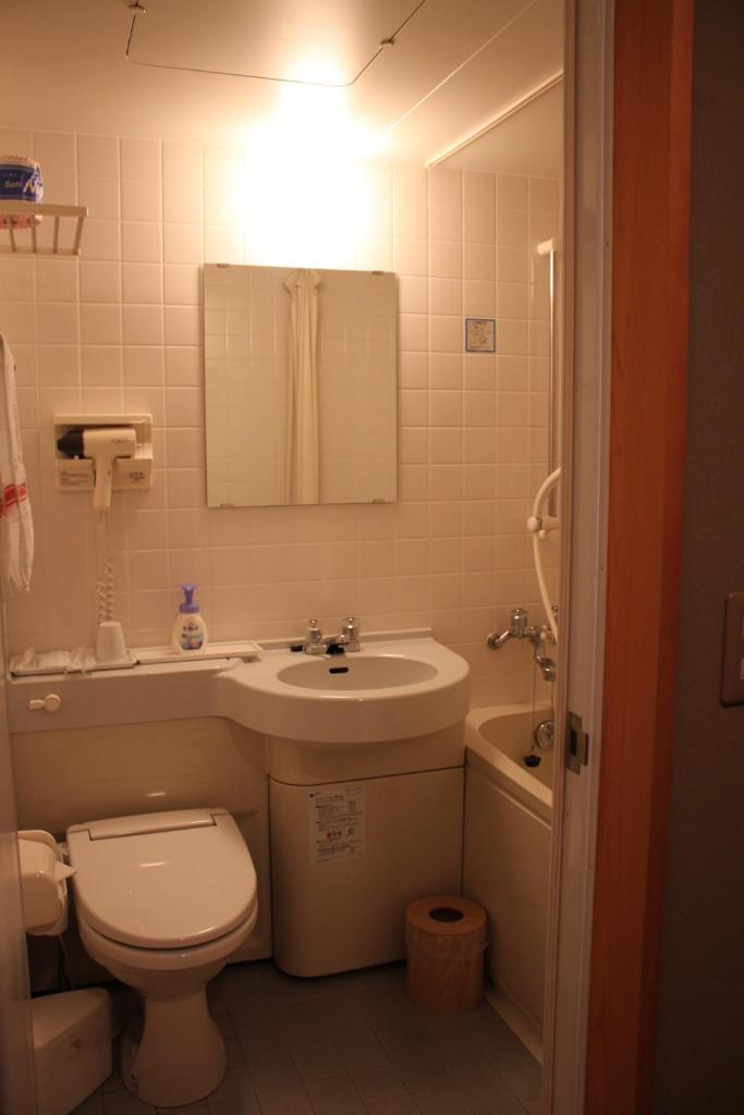 une salle de bain avec des toilettes blanches et un lavabo dans l'établissement Oyado Seri, à Toyooka 30 autres photos