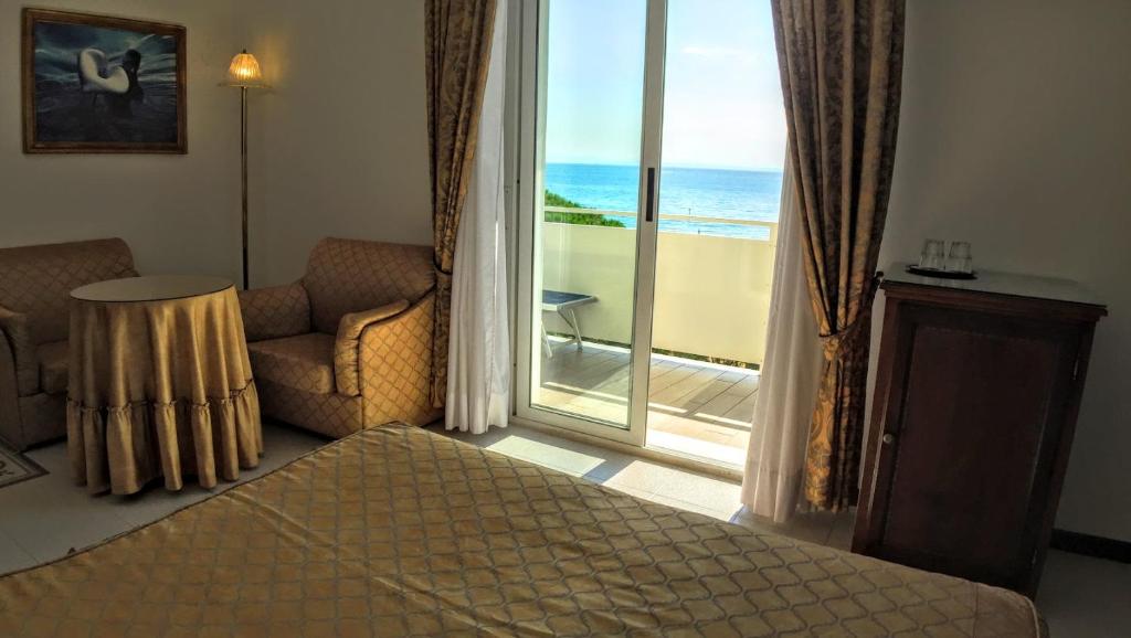 une chambre avec un lit et une vue sur l'océan dans l'établissement Hotel Miramare, à Lignano Sabbiadoro