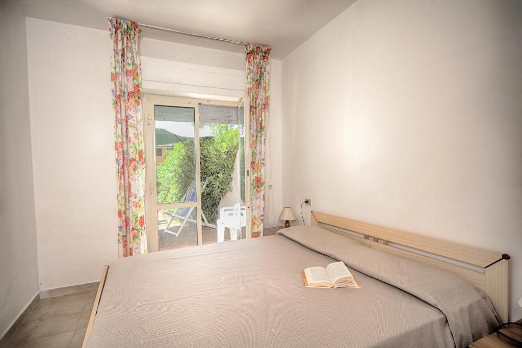 une chambre avec un lit avec deux livres dessus dans l'établissement Residence Airone, à Orbetello