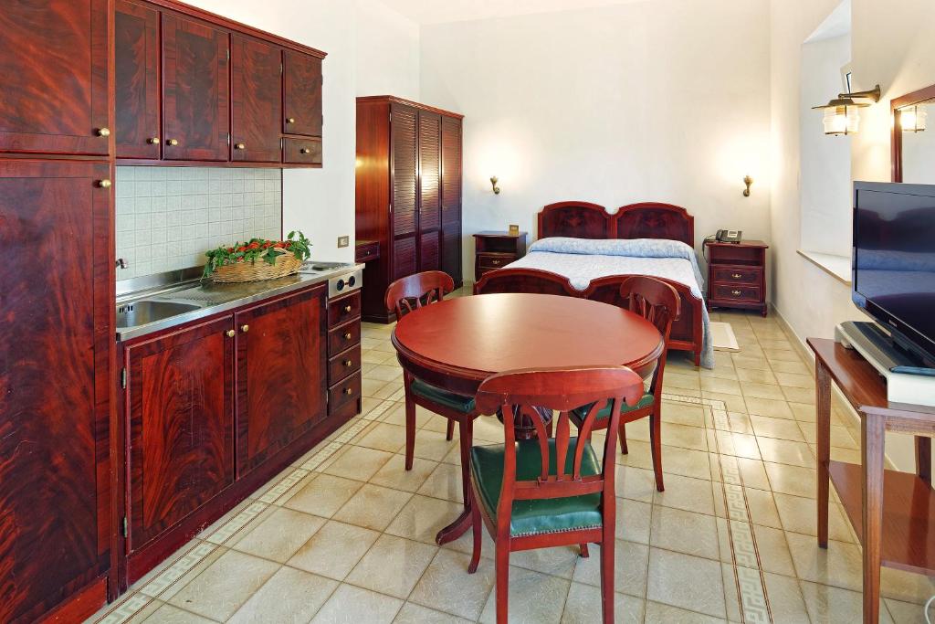 une cuisine et une salle à manger avec une table et un lit dans l'établissement Parco Smeraldo Appartamenti, à Ischia 34 autres photos