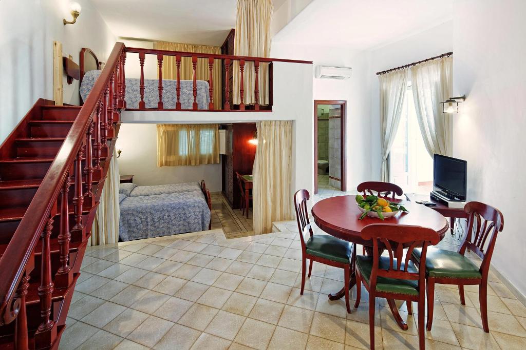 un salon avec une table et une chambre dans l'établissement Parco Smeraldo Appartamenti, à Ischia