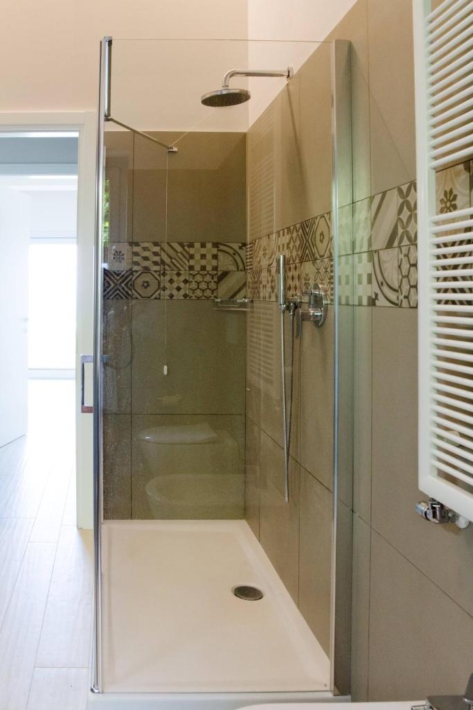 une douche avec une porte vitrée dans une salle de bain dans l'établissement Villa Elysium, à Torri del Benaco