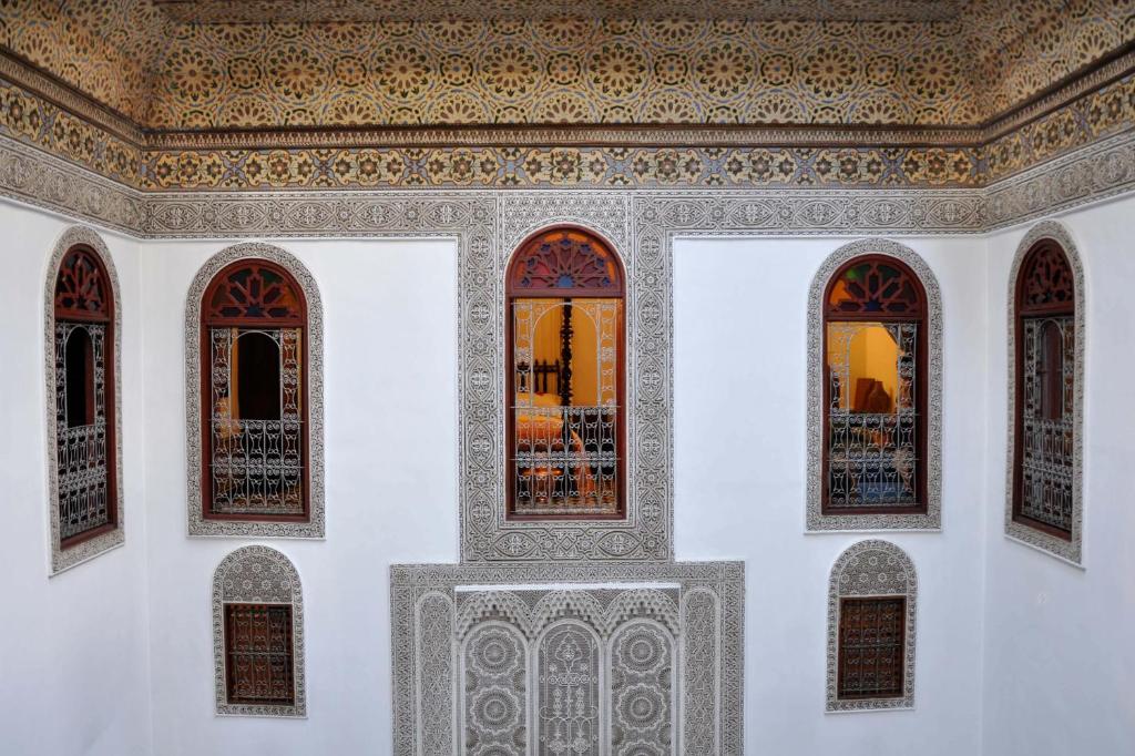 Cette chambre dispose de trois fenêtres et d'un plafond. dans l'établissement La Maison Bleue Batha, à Fès