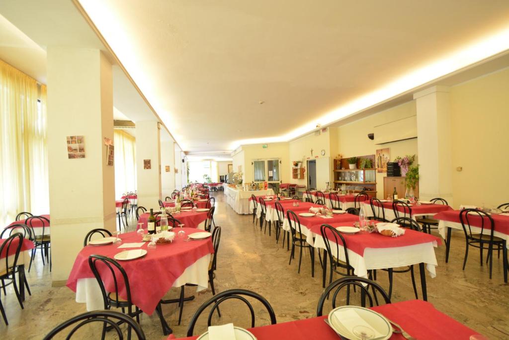 un restaurant avec des tables et des chaises rouges et blanches dans l'établissement Hotel Europa, à Rimini