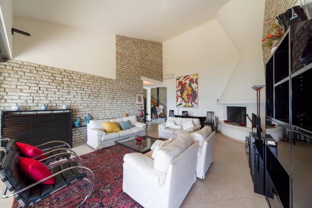 - un salon avec des canapés blancs et un mur en briques dans l'établissement Villa Elysium, à Torri del Benaco