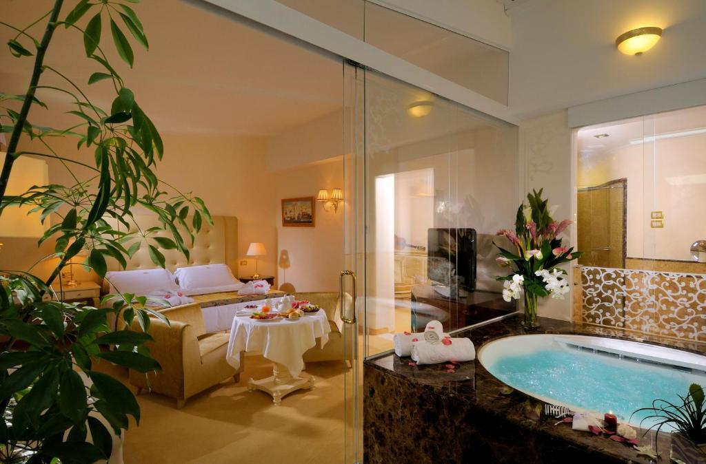 une salle de bain avec baignoire et un salon dans l'établissement Hotel De Londres, à Rimini