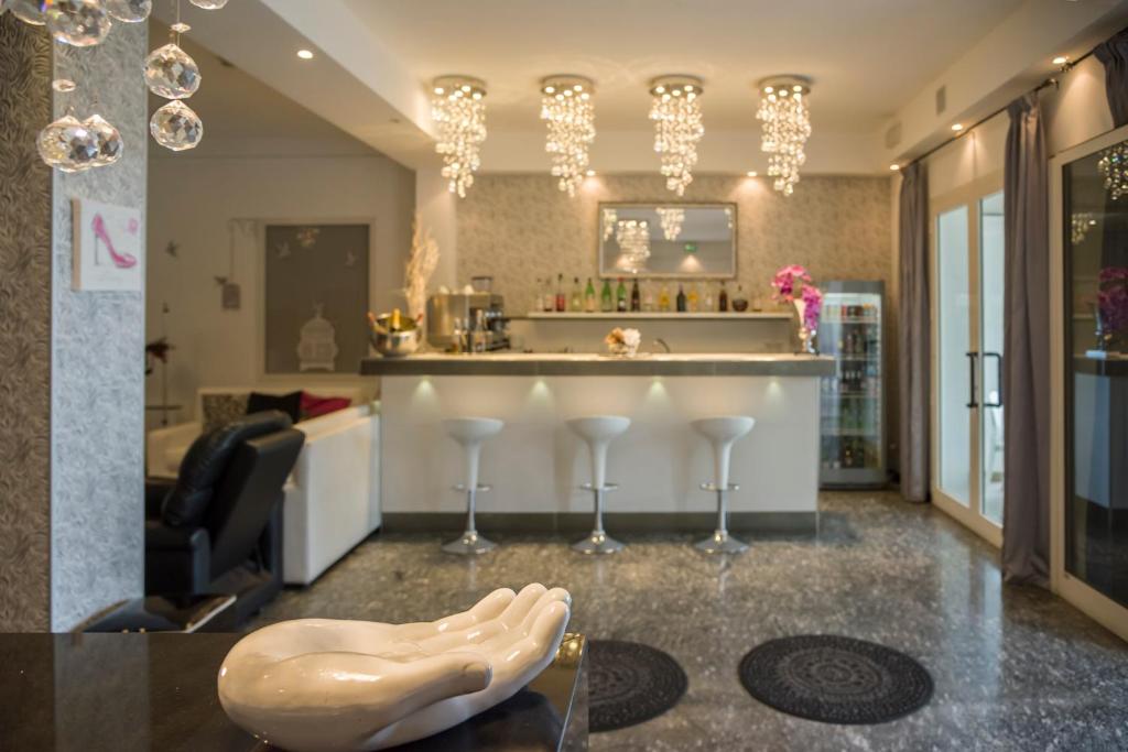 - un salon avec un bar et des verres à vin dans l'établissement Hotel Vela D'Oro, à Riccione