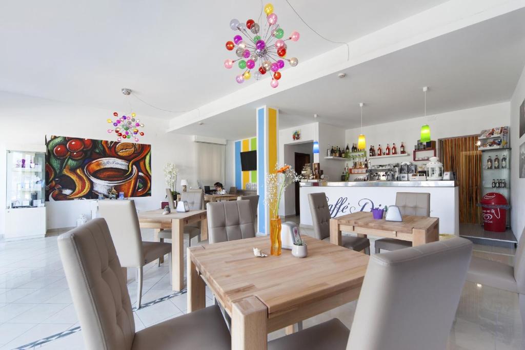 une salle à manger avec tables et chaises et une cuisine dans l'établissement Hotel del Mar, à Sottomarina