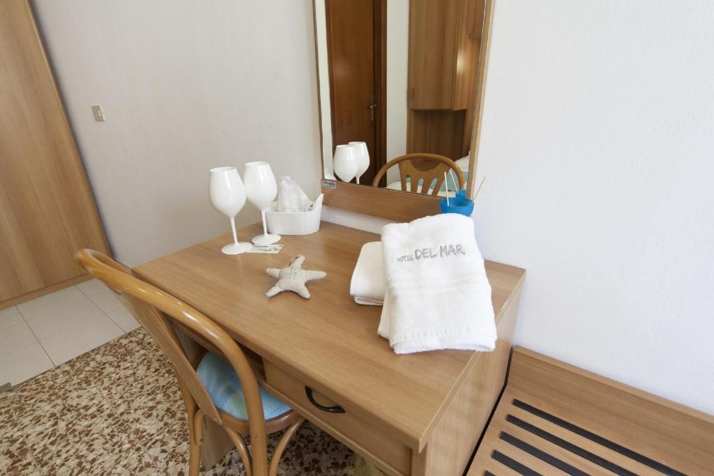 une table avec un miroir et une table en bois avec des chaises dans l'établissement Hotel del Mar, à Sottomarina