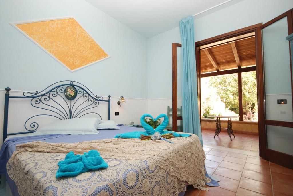 une chambre avec un lit avec des serviettes bleues dessus dans l'établissement Hotel Oasi da Paolo, à Castelluzzo