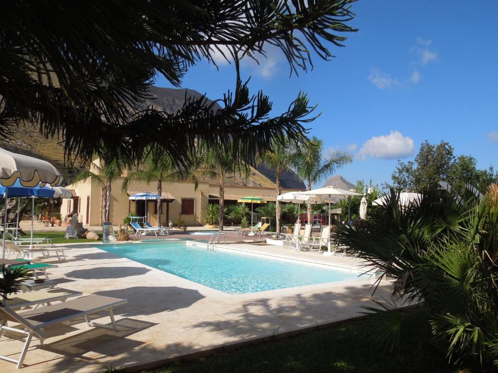 - une piscine avec des chaises et des parasols à côté d'une maison dans l'établissement Hotel Oasi da Paolo, à Castelluzzo