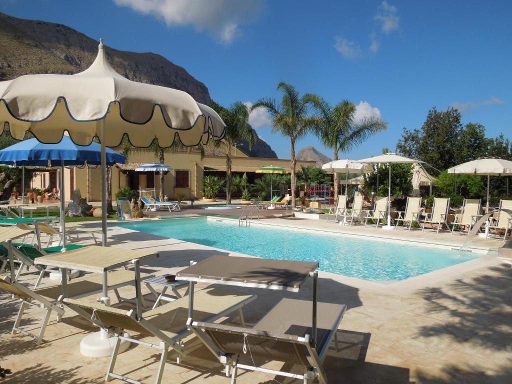 une piscine avec chaises, tables et parasols dans l'établissement Hotel Oasi da Paolo, à Castelluzzo