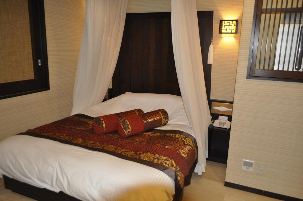 une chambre avec un lit avec deux oreillers dessus dans l'établissement Hotel Woo (Adults Only), à Yamatotakada