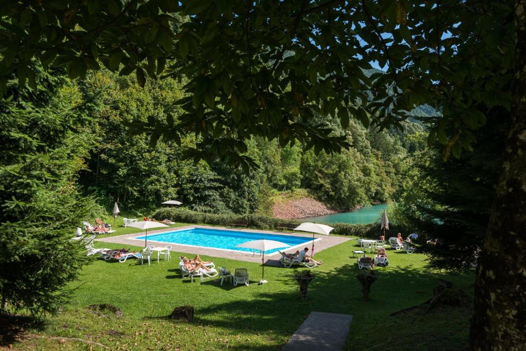 un groupe de personnes assises autour d'une piscine dans l'établissement Grand Hotel Molveno, à Molveno