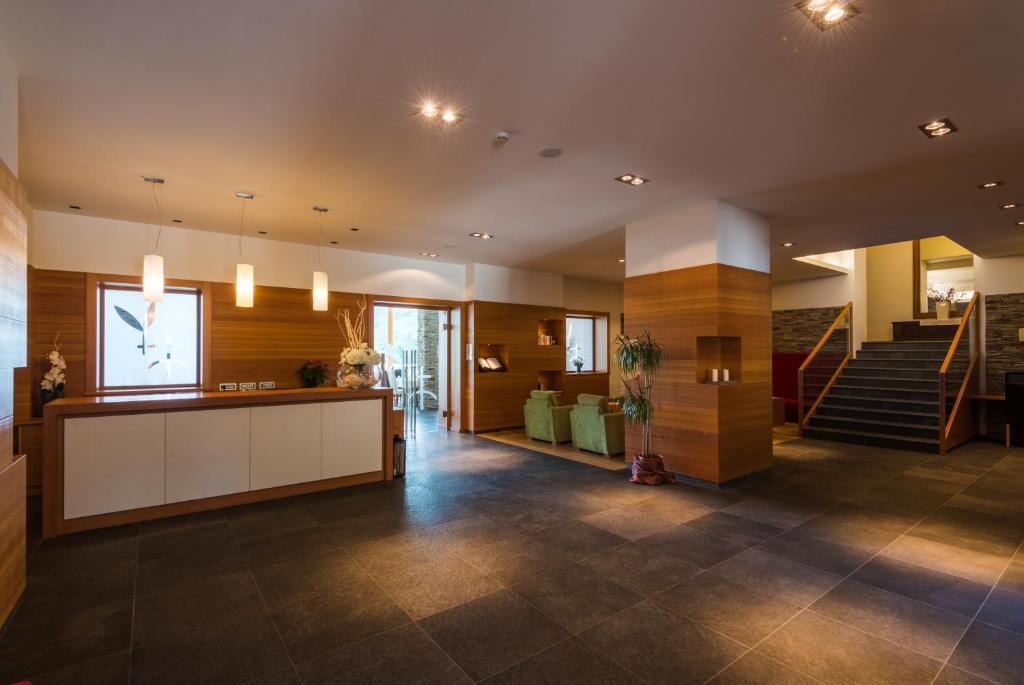 un hall avec un escalier et une réception dans l'établissement Grand Hotel Molveno, à Molveno