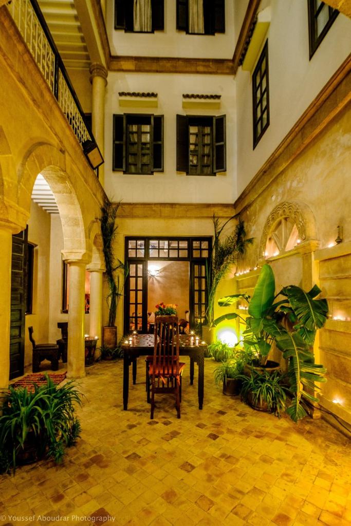 une cour avec une table et des chaises dans un bâtiment dans l'établissement RIAD DAR ASSALAMA Terrasse Vue Mer, à Essaouira