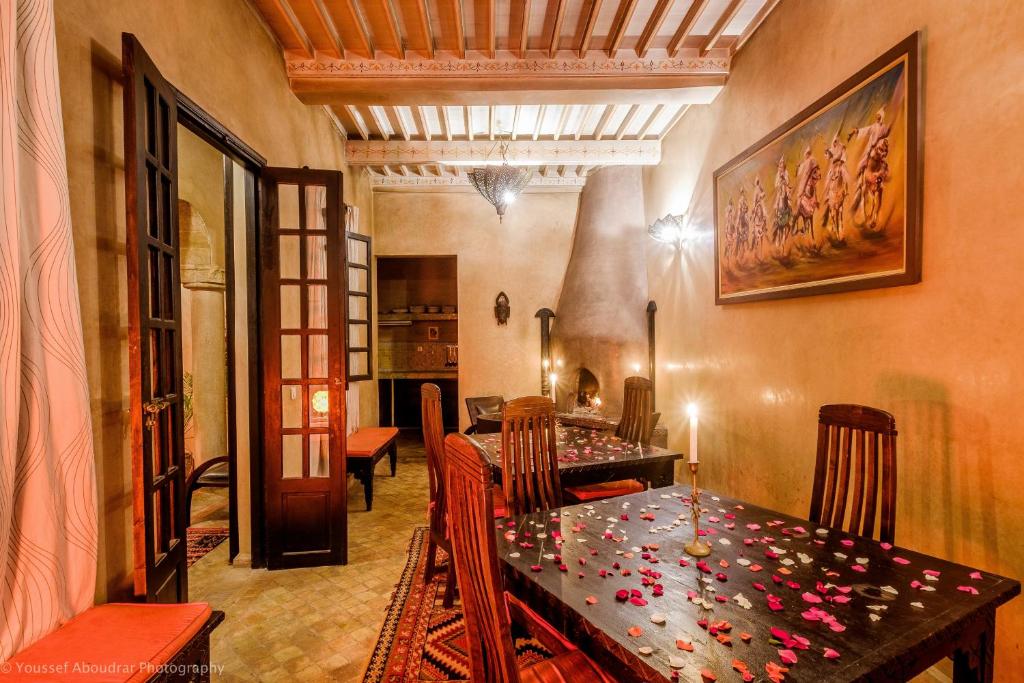 - une salle à manger avec une table et des fleurs dans l'établissement RIAD DAR ASSALAMA Terrasse Vue Mer, à Essaouira