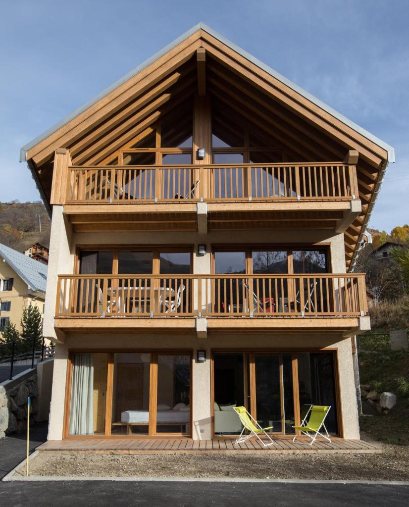 une maison dotée d'une grande terrasse avec deux chaises dans l'établissement Les Sabots d'Hélène, à Valloire