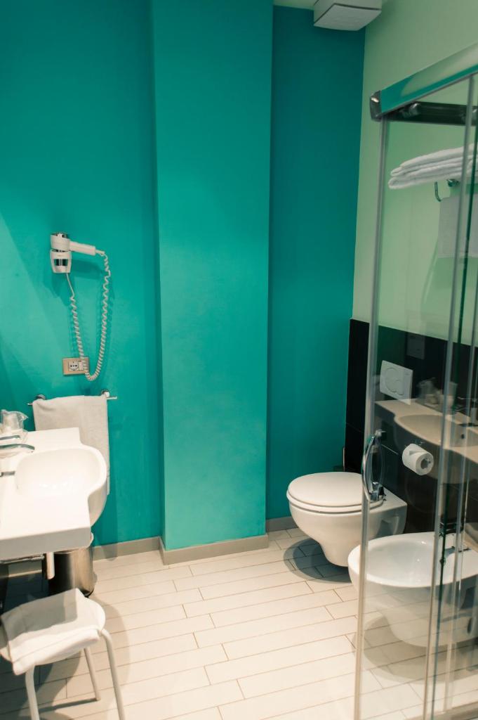 une salle de bain bleue avec des toilettes et un lavabo dans l'établissement Hotel & Residence Cavalluccio Marino, à Rimini