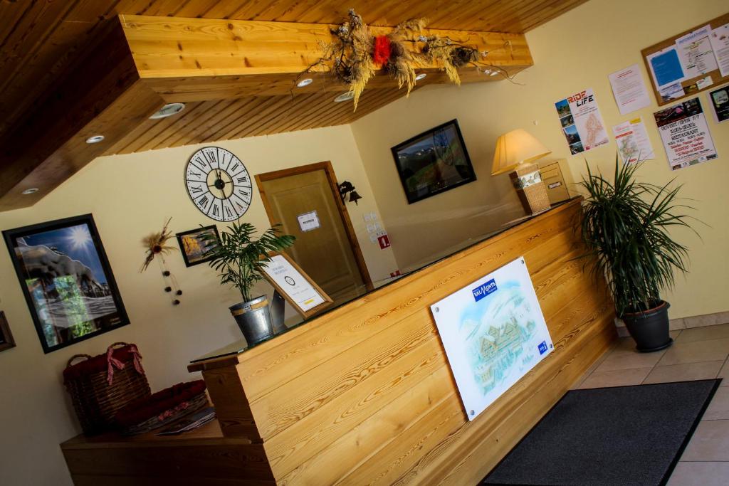 le hall d'un magasin avec une horloge sur le mur dans l'établissement Résidence les Valmonts Vaujany, à Vaujany