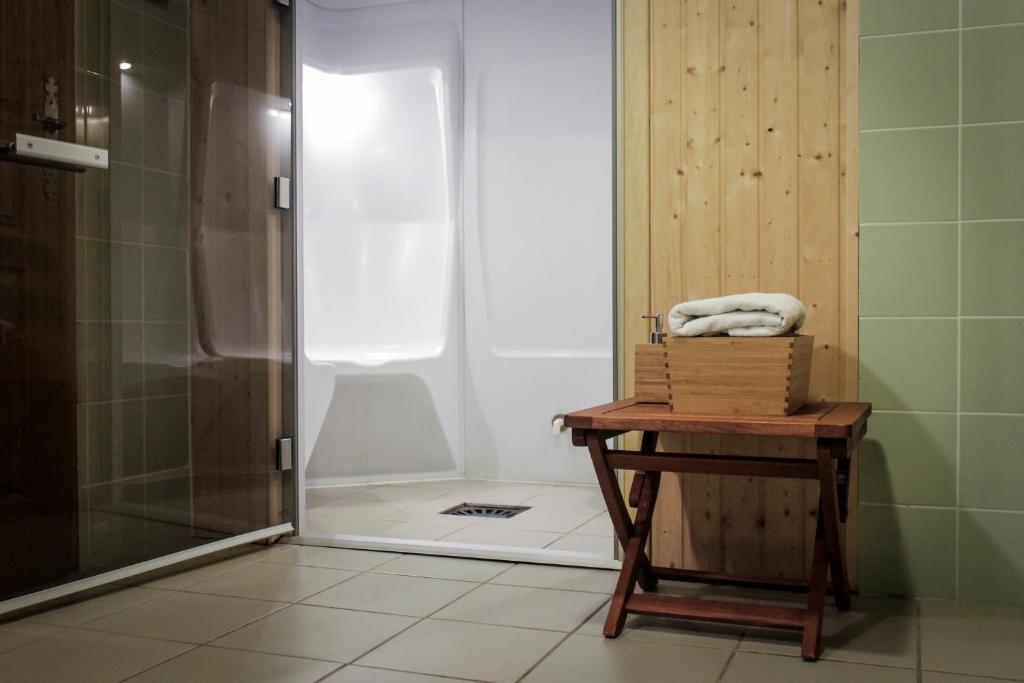 La salle de bains est pourvue d'une douche et d'une table avec une serviette. dans l'établissement Résidence les Valmonts Vaujany, à Vaujany
