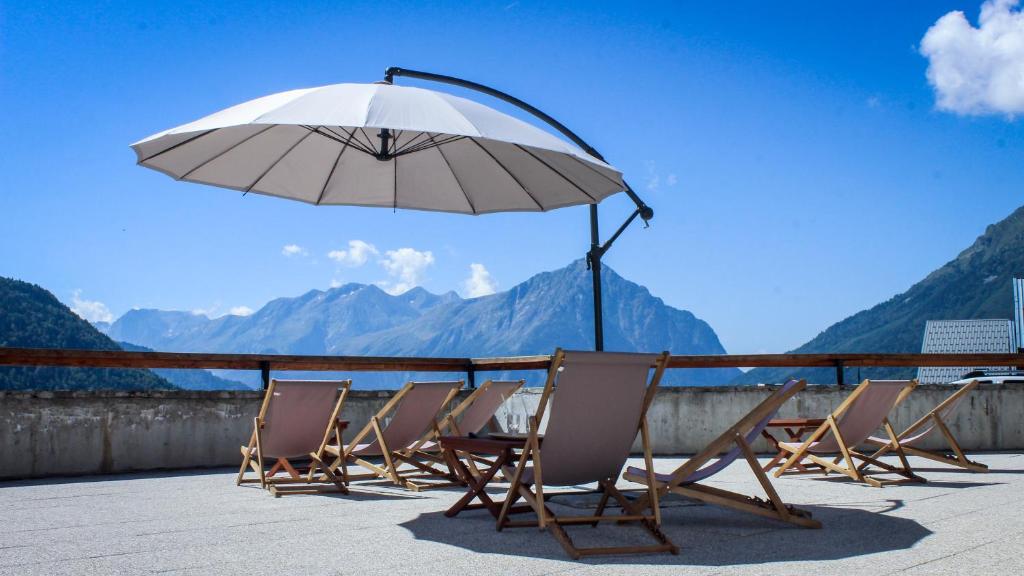 - un balcon avec des chaises et un parasol dans l'établissement Résidence les Valmonts Vaujany, à Vaujany