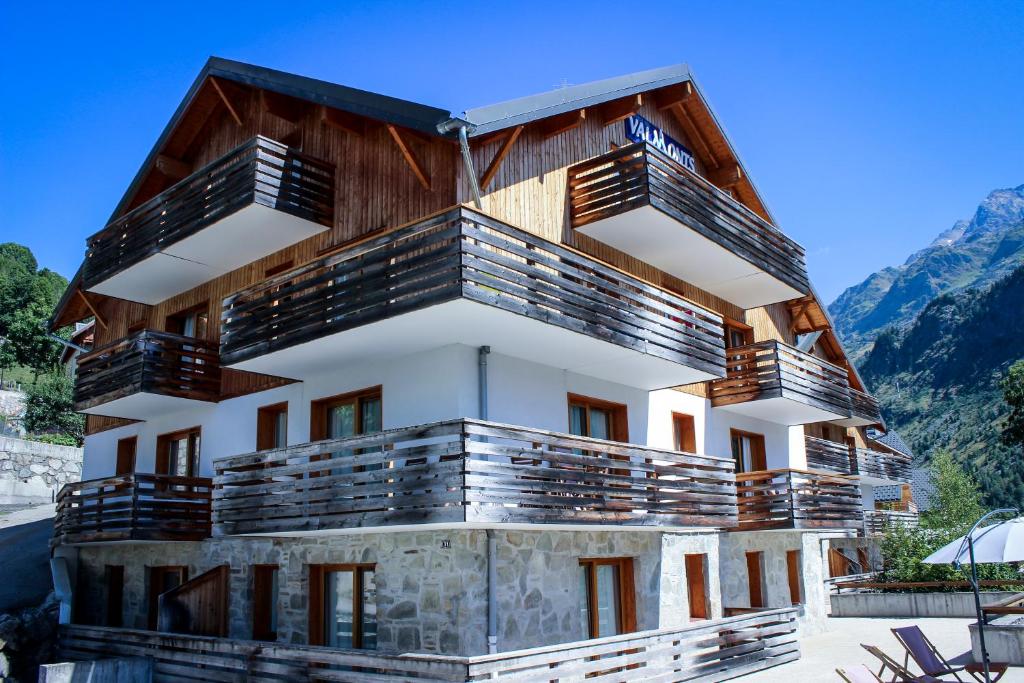 un bâtiment avec des balcons en bois sur une montagne dans l'établissement Résidence les Valmonts Vaujany, à Vaujany