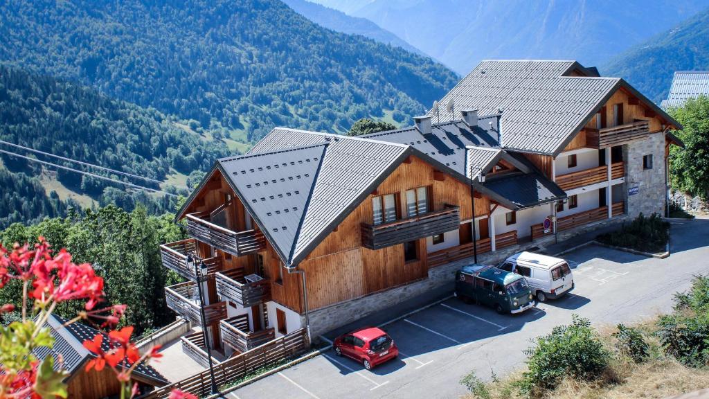 Vue de tête d'une maison avec des montagnes en arrière-plan dans l'établissement Résidence les Valmonts Vaujany, à Vaujany