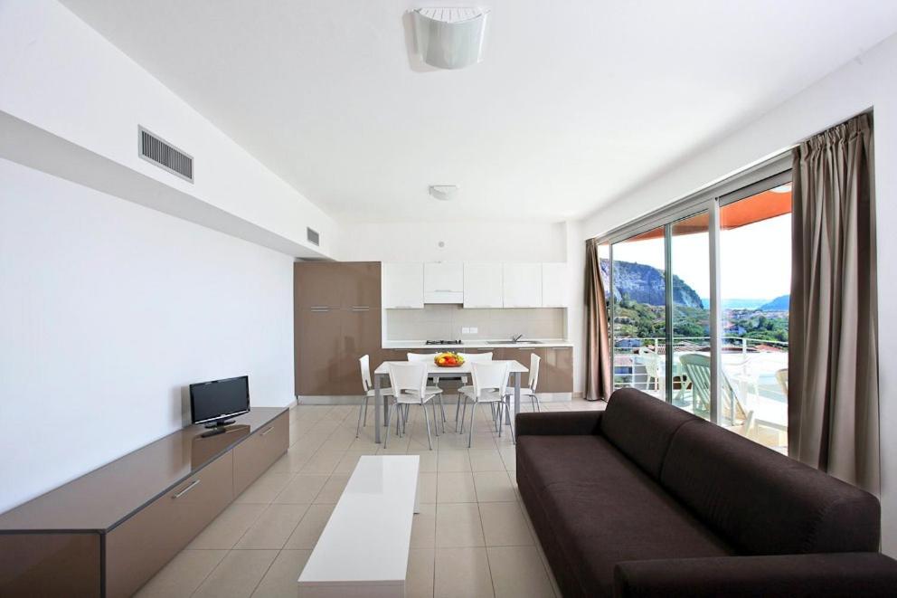 un grand salon avec un canapé et une cuisine dans l'établissement Sporting Club Resort, à Praia a Mare