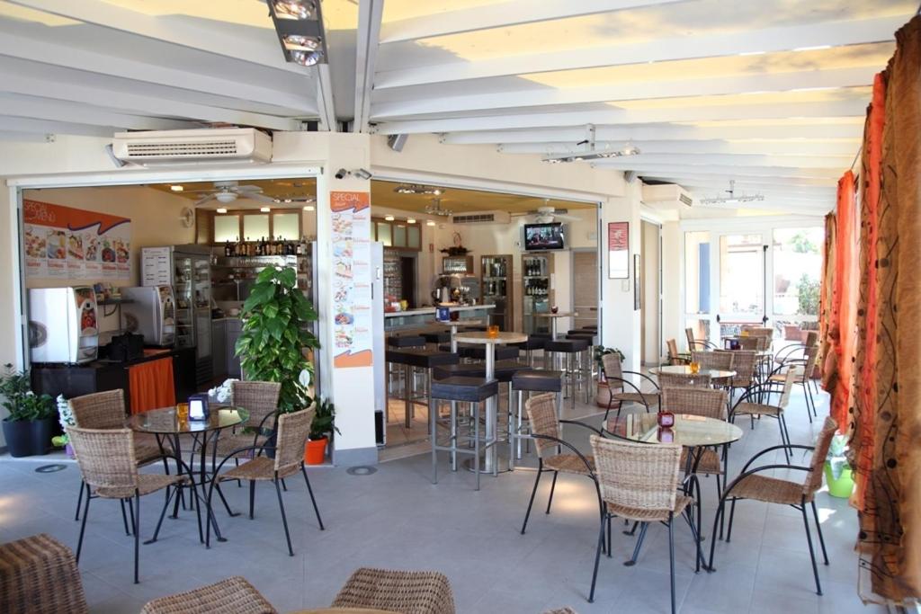 un restaurant avec des tables et des chaises dans une salle dans l'établissement Aparthotel Gioia, à Caorle