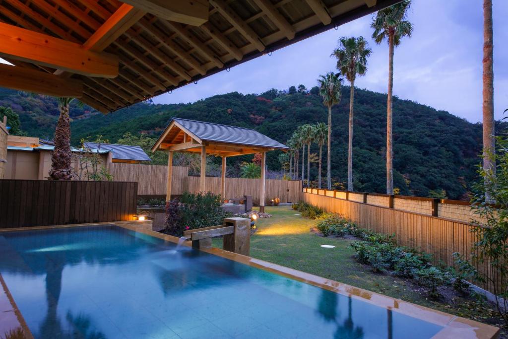 - une piscine dans une arrière-cour avec une clôture dans l'établissement Hotel Tokinoza, à Kihokucho