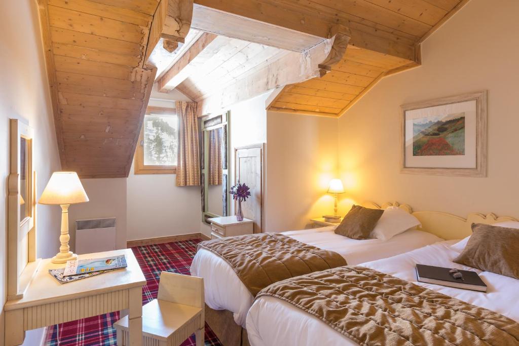 une chambre d'hôtel avec deux lits et une fenêtre dans l'établissement Residence Arc 1950 Le Village - maeva Home, à Arc 1950 37 autres photos