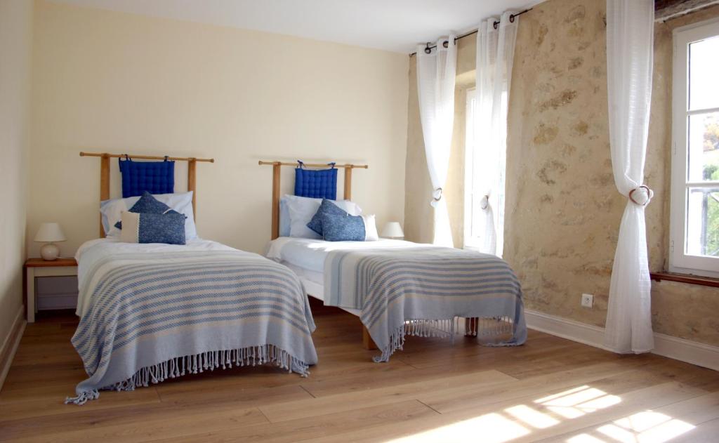 une chambre avec deux lits avec des draps bleus et blancs dans l'établissement Jj French Gites, à Pécharic-et-le-Py