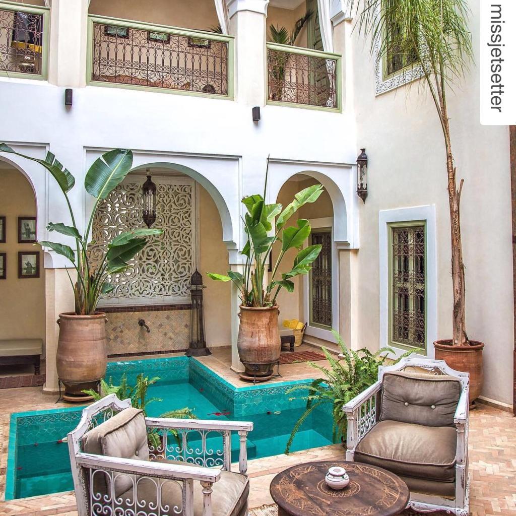 un patio avec des chaises et une table devant un bâtiment dans l'établissement Riad Palacio De Las Especias, à Marrakech
