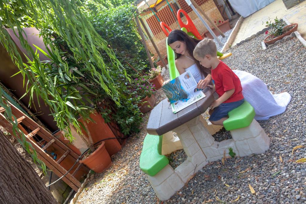 Un jeune garçon assis à une table avec une femme dans l'établissement Residence La Palma, à Marina dʼAndora 90 autres photos