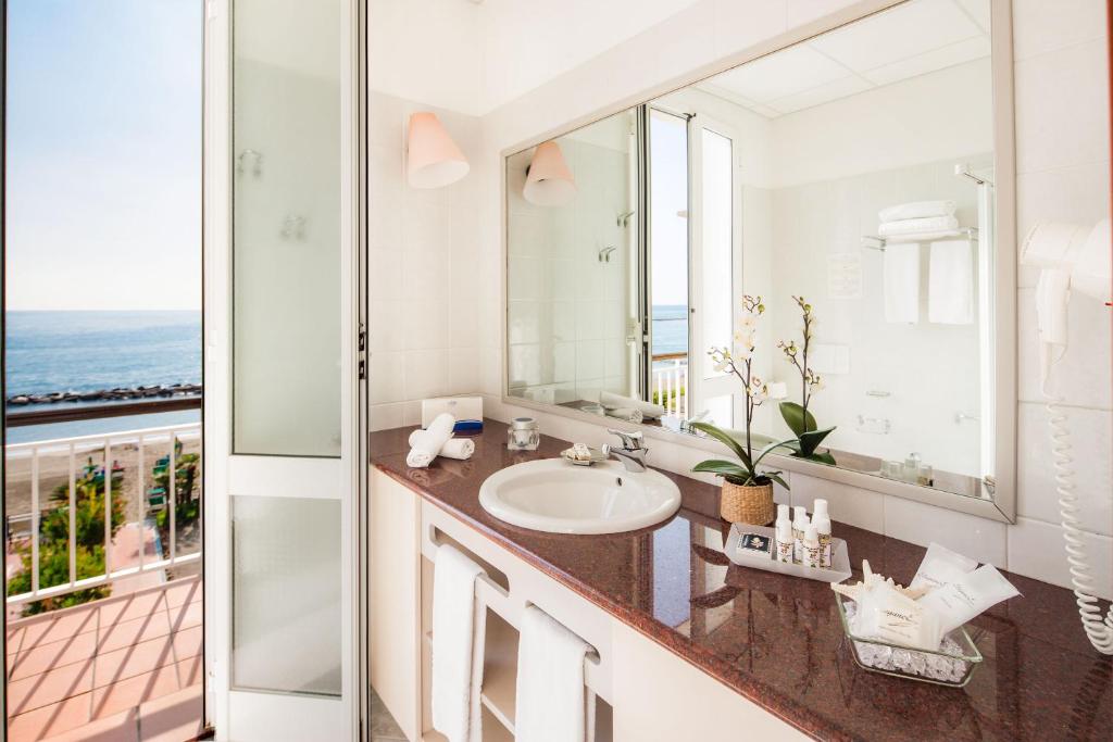 une salle de bain avec un lavabo et un miroir dans l'établissement Hotel Gabriella, à Diano Marina